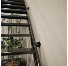 Detailaufnahme einer schwarzen Stahltreppe an einer Wand