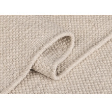 Detailansicht eines hellen Teppichs mit gewebter Textur