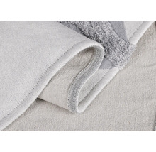 Detailaufnahme einer hellen Badematte aus Textil