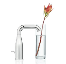 Wasserhahn mit einer Blume in einem Glas Wasser
