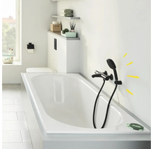 Badezimmer mit Badewanne, schwarzer Armatur und Ablageflächen