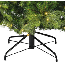Detailansicht eines künstlichen Weihnachtsbaums mit Beleuchtung und schwarzem Metallständer