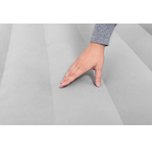 Detailaufnahme einer Hand, die die Oberfläche einer Luftmatratze berührt, um die Textur und den Komfort zu zeigen
