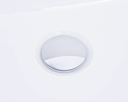 Detailansicht eines runden, verchromten Ablaufventils in einem Waschbecken.