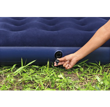 Aufblasbare Matratze mit Hand am Ventil auf Gras