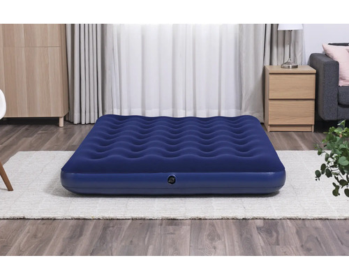 Blaue Luftmatratze im Innenraum auf einem Teppich