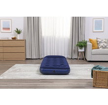 Aufblasbare Matratze in einem Wohnzimmer mit Teppich, Kommode und Sofa.
