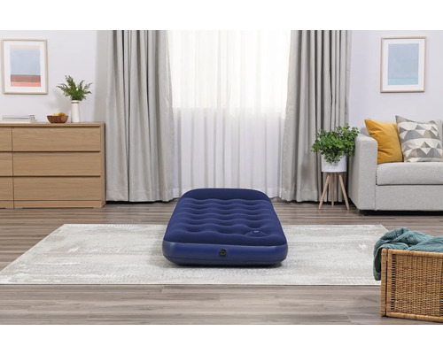 Aufblasbare Matratze in einem Wohnzimmer mit Teppich, Kommode und Sofa.