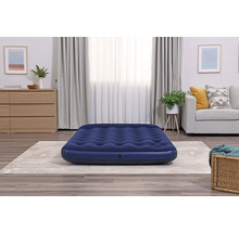 Blaues Luftbett im Wohnzimmer auf einem Teppich
