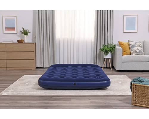 Blaues Luftbett im Wohnzimmer auf einem Teppich