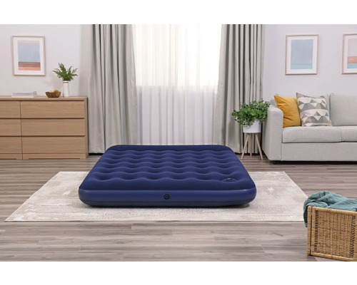 Blaues Luftbett im Wohnzimmer auf dem Teppich