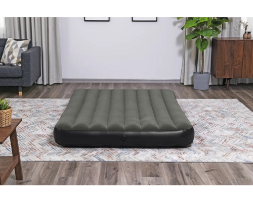 Aufblasbare Gästematratze auf einem Teppich in einem Wohnzimmer