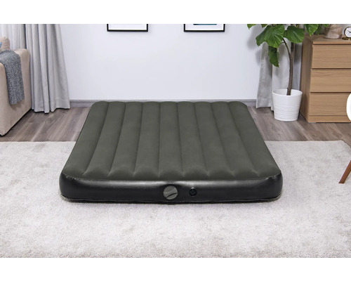 Aufblasbare Gästematratze im Wohnzimmer auf einem Teppich.