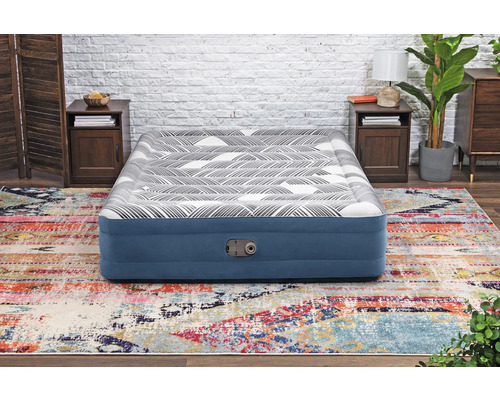 Aufblasbares Gästebett auf einem farbenfrohen Teppich in einem Schlafzimmer.