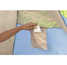 Nahaufnahme einer Hand, die ein Smartphone in eine Tasche im Inneren eines Zeltes steckt