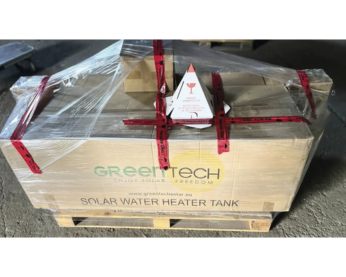 Verpackter Solarwasserspeicher von Green Tech auf Palette mit Warnhinweisen für zerbrechliches Glas