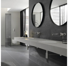 Modernes Badezimmer mit Doppelwaschbecken, runden Spiegeln und grauer Fliesenwand.