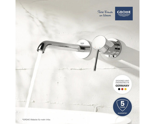 Aufputz-Waschtischarmatur mit fließendem Wasser vor einer weißen Wand. Grohe Logo. Hergestellt in Deutschland. Fünf Jahre Garantie.