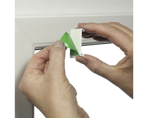 Person entfernt Schutzfolie von Fensterhaken zur Montage