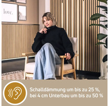 Eine Frau sitzt auf einem Stuhl vor einer Holzpaneelwand zur Schalldämmung.