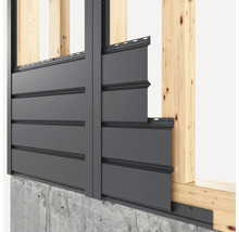 Fassadenverkleidung an einer Hauswand mit Holzrahmen und Betonsockel