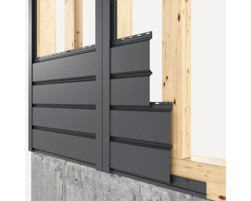 Fassadenverkleidung an einer Hauswand mit Holzrahmen und Betonsockel