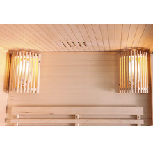 Innenraum einer Sauna mit Holzwänden, einer Sitzbank und zwei Lampen mit Holzschutzgittern.