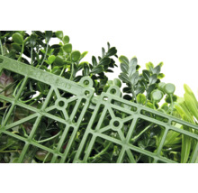 Künstliche Pflanzenwand mit grünen Blättern und Kunststoffgitter