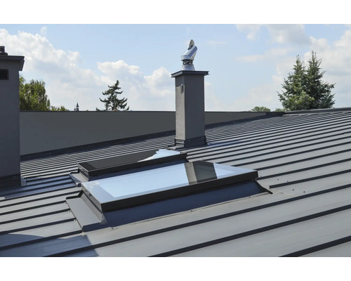 Metalldach mit Dachfenster und Schornstein