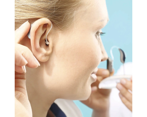 Frau setzt ein Hörgerät ein