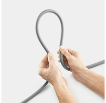 Grauer Wasserschlauch wird von zwei Händen gehalten.