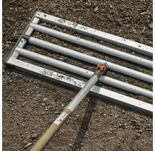 Gardena Combisystem Saatbeetegge im Einsatz auf einem Erdboden.