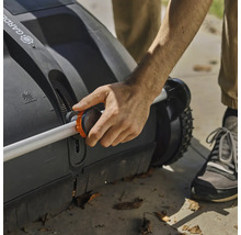 Person bedient einen Rasenkehrer mit verstellbarem Griff.