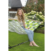 Frau entspannt in Hängematte mit Blattmuster im Garten