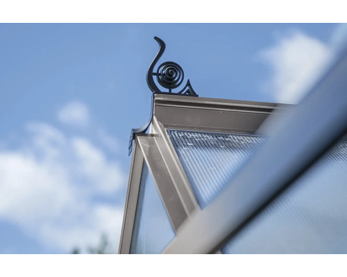 Detailansicht eines Gewächshauses mit dekorativer Spitze vor blauem Himmel