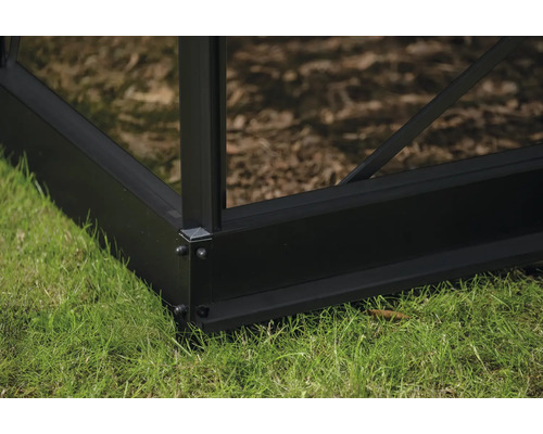 Detailansicht des Fundaments eines Gewächshauses mit Aluminiumrahmen auf Gras