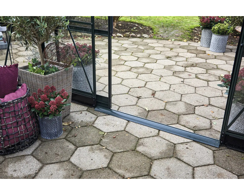 Außenbereich mit Gewächshaus, sechseckigen Pflastersteinen und bepflanzten Körben