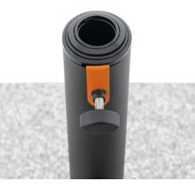 Aufgerollte, schwarze Fitnessmatte mit orangem Verschluss