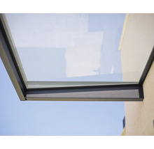 Modernes Vordach aus Glas mit anthrazitfarbenem Metallrahmen an einer Hauswand.