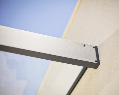 Wandanschluss einer Glasvordach-Halterung aus Aluminium mit sichtbaren Schrauben.