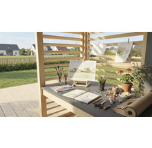 Kreativer Arbeitsbereich im Freien mit Staffelei, Farben, Pinsel, Papier und Blumen