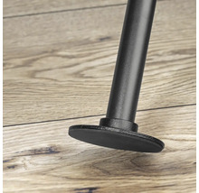 Detailaufnahme eines schwarzen Möbelbeins mit Fuß auf einem Holzboden.