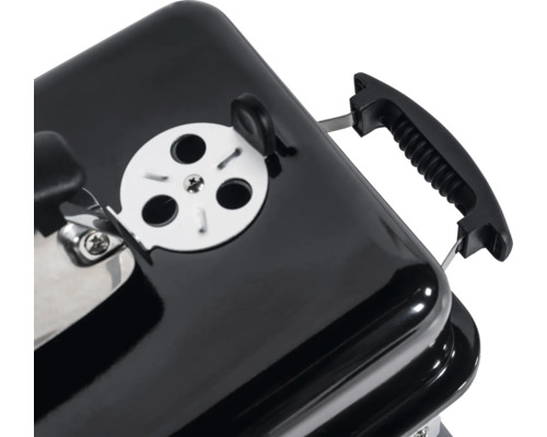 Detailansicht eines Holzkohlegrills mit Lüftungsschieber und Griff