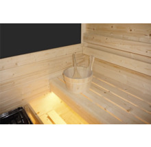Innenausstattung einer Sauna mit Holzwänden und Holzbänken sowie einem Holzeimer mit Schöpfkelle