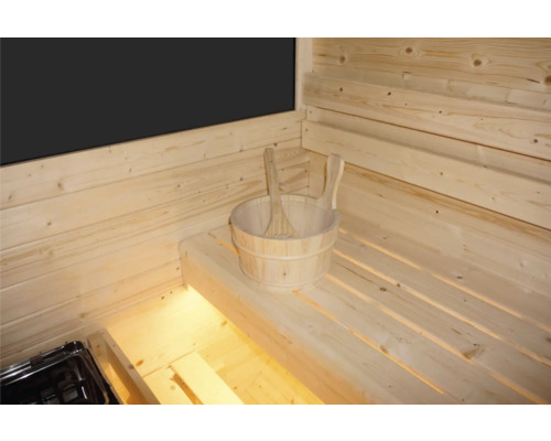 Innenausstattung einer Sauna mit Holzwänden und Holzbänken sowie einem Holzeimer mit Schöpfkelle