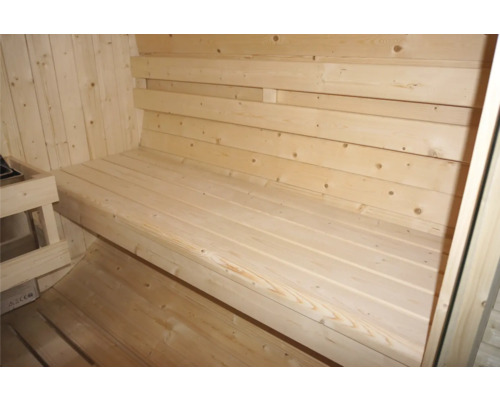 Innenraum einer Sauna mit Holzbänken und Holzverkleidung