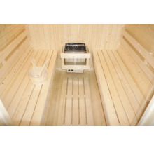 Innenraum einer Sauna mit Holzbänken, Saunaofen und Holzkübel