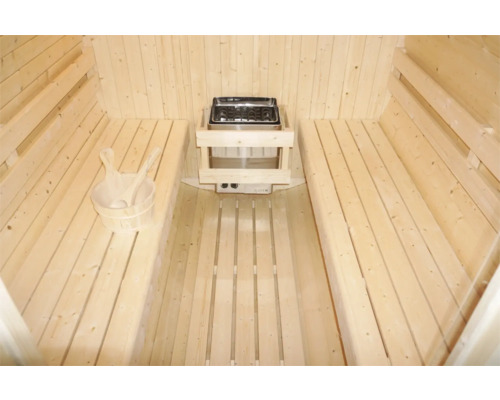 Innenraum einer Sauna mit Holzbänken, Saunaofen und Holzkübel
