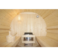 Innenansicht einer Fasssauna mit Bänken, Ofen, Lampe, Uhr und Saunaeimer mit Kelle