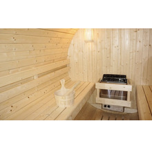 Innenansicht einer Holzfasssauna mit Bänken, Saunaofen und Saunazubehör
